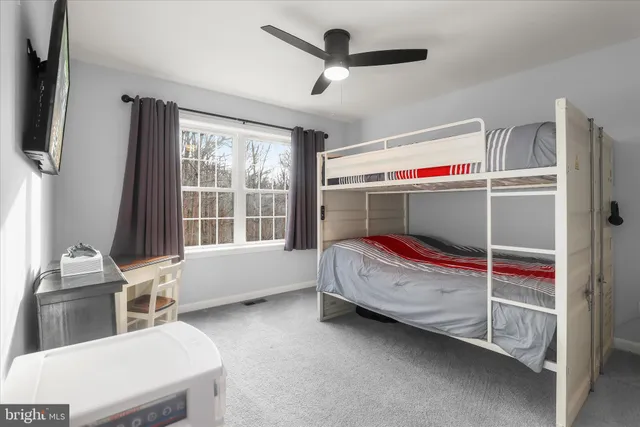 a spacious bedroom with a bed and a lamp