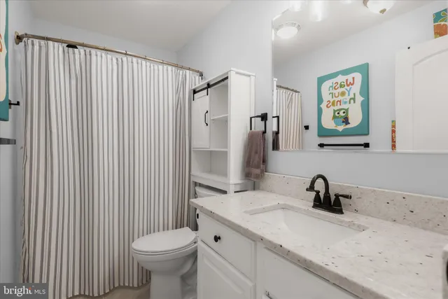a living room with furniture kitchen view and a window