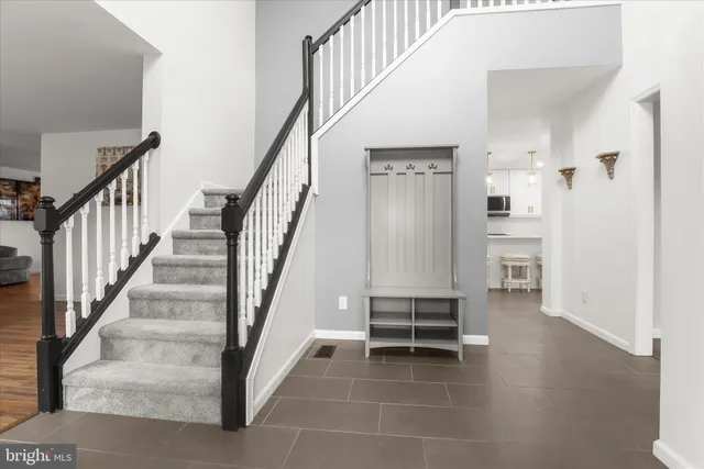 a large white kitchen with kitchen island a stove a sink a refrigerator and a fireplace