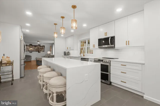 a large kitchen with kitchen island a sink a stove and a refrigerator