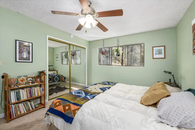 a bedroom with a bed furniture a chandelier and a book shelf