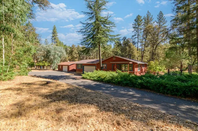 a front view of a house with a yard and trees