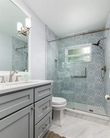 a bathroom with a sink a toilet and shower