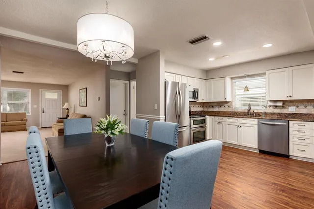 a kitchen with refrigerator dining table and chairs