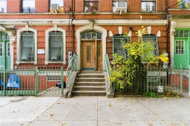 a front view of a building with a garden