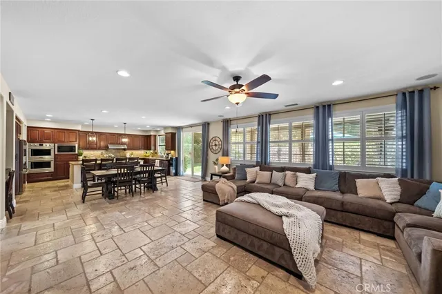a kitchen with stainless steel appliances granite countertop table chairs stove refrigerator and cabinets