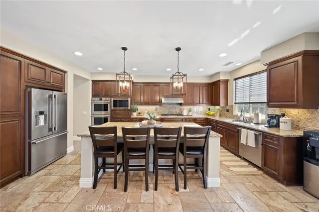 a kitchen with stainless steel appliances granite countertop a stove sink and cabinets