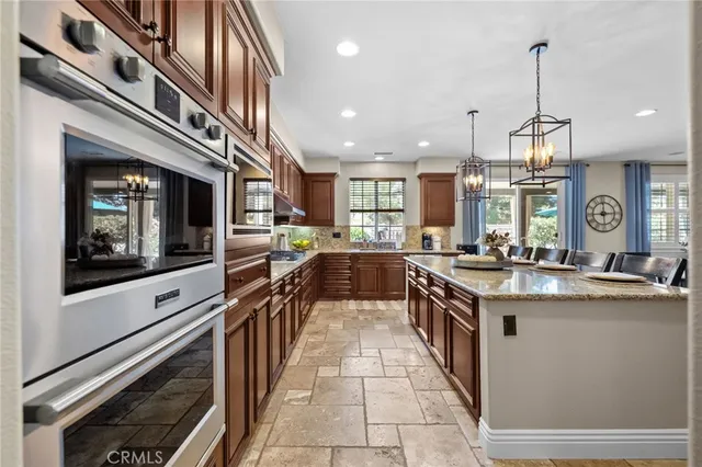 a kitchen with granite countertop stainless steel appliances a sink counter space and a center island