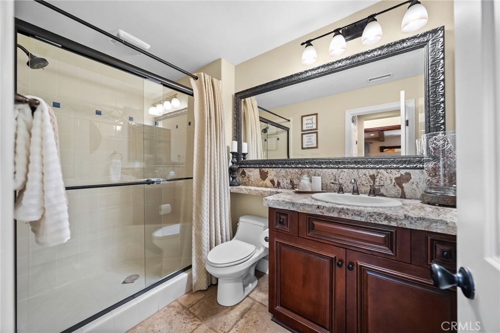 46331 Hunter Trail Temecula, CA 92592 - Photo 28 of 62 a bathroom with a granite countertop sink toilet and shower