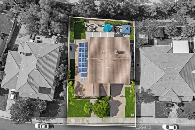 an aerial view of a house with a yard and large tree