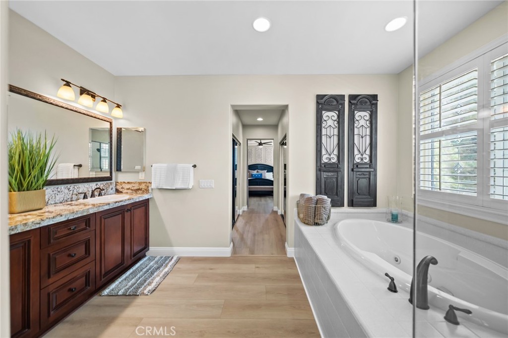 46331 Hunter Trail Temecula, CA 92592 - Photo 42 of 62 a bathroom with a tub a double vanity sink a mirror and a shower