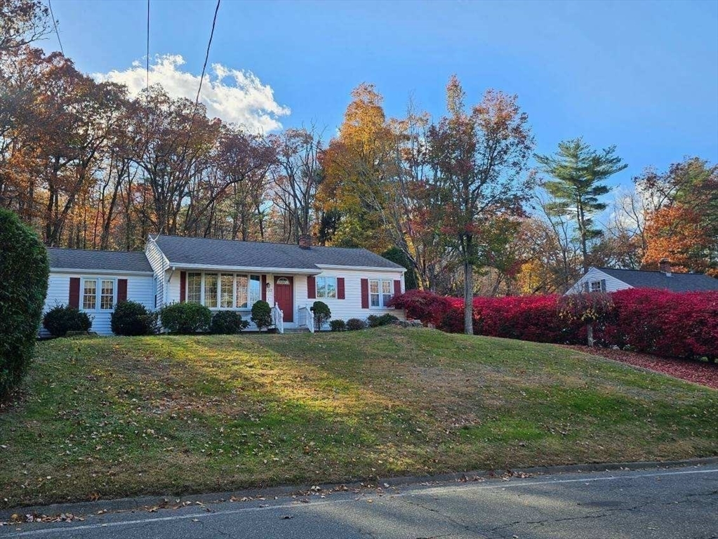a view of a yard in front of a house with large trees