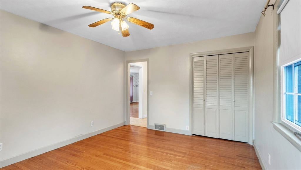 2022 Calkins Road Palmer, MA 01069 - Photo 27 of 38 an empty room with wooden floor chandelier fan and windows