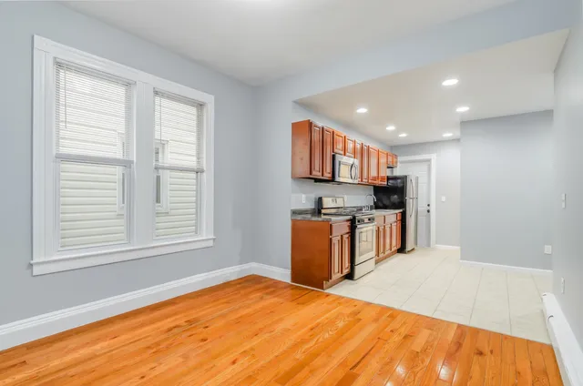 a kitchen with stainless steel appliances kitchen island a refrigerator sink and cabinets