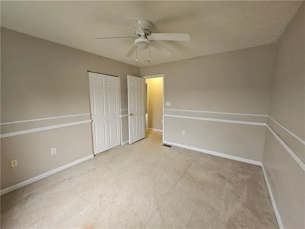 an empty room with a ceiling fan and shower