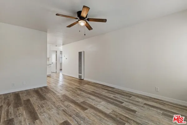a view of a livingroom with wooden floor and a ceiling fan
