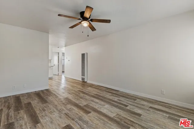 a view of a livingroom with wooden floor and a ceiling fan