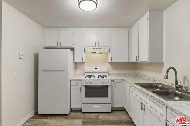 a kitchen with a stove top oven sink and cabinets