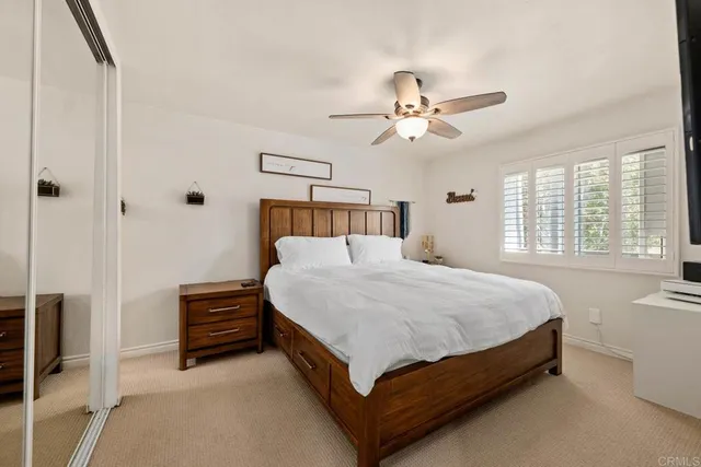 a bed sitting in a spacious bedroom next to a window