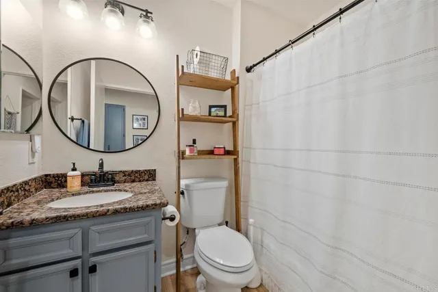 a bathroom with a toilet a sink and a mirror