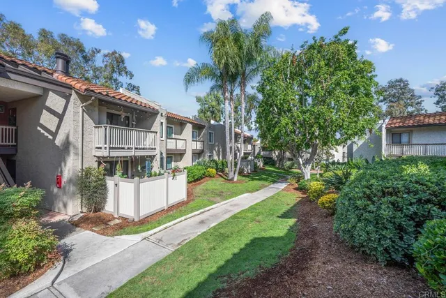 a front view of a house with a yard and potted plants