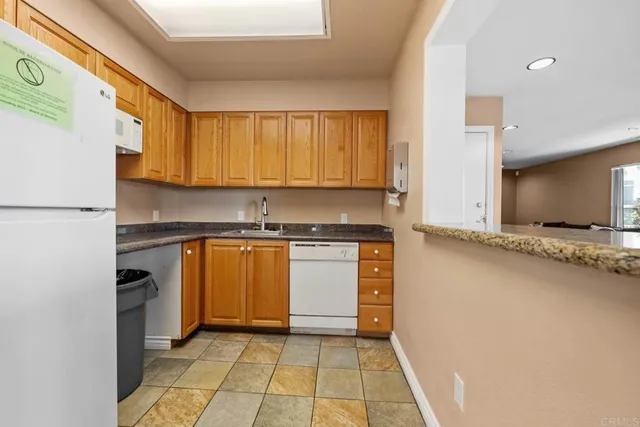 a kitchen with a refrigerator sink and cabinets