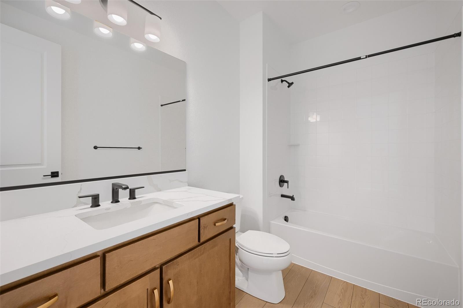 1735 Keystone Crest Lane Colorado Springs, CO 80904 - Photo 18 of 30 a bathroom with a sink toilet a mirror and shower