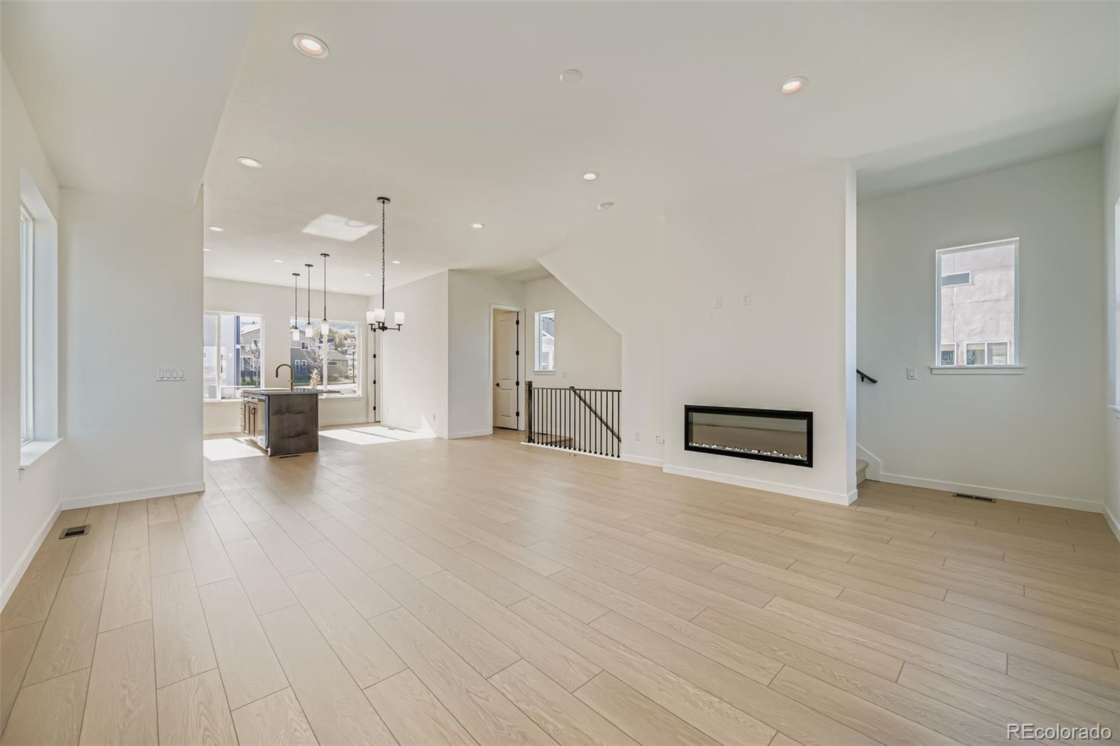 1735 Keystone Crest Lane Colorado Springs, CO 80904 - Photo 5 of 30 an empty room with wooden floor and kitchen view