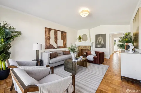 a living room with furniture fireplace and a large window