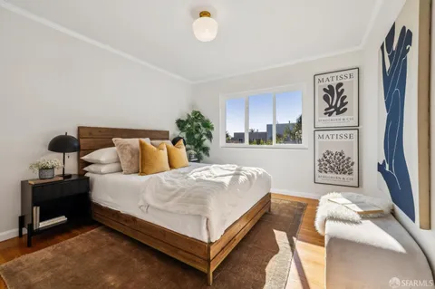 a bedroom with a bed and a potted plant