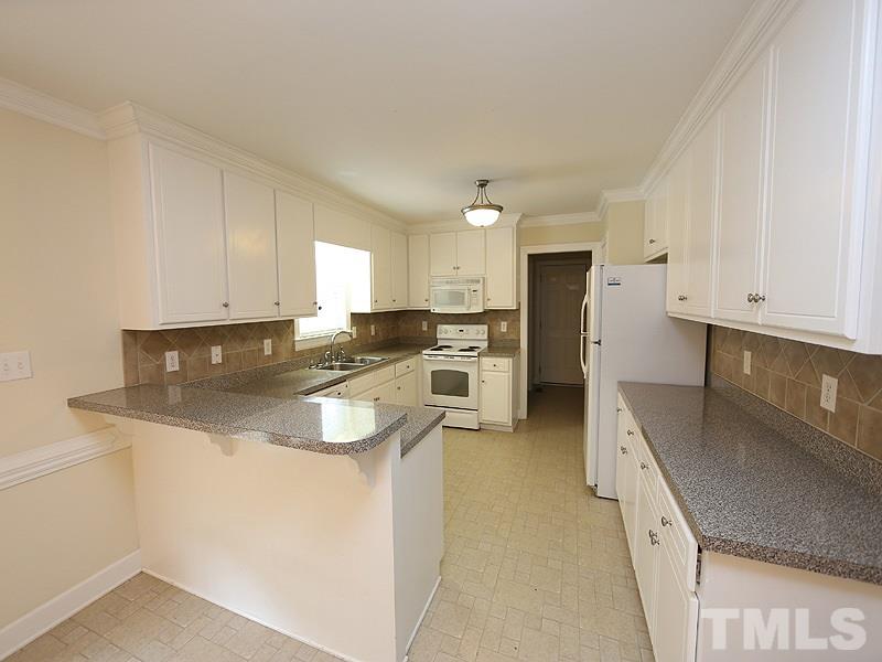 4689 Seven Paths Road Spring Hope, NC 27882 - Photo 3 of 12 a kitchen with stainless steel appliances granite countertop a sink stove and refrigerator