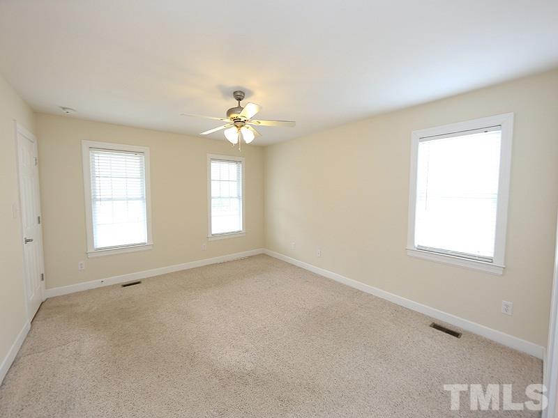 4689 Seven Paths Road Spring Hope, NC 27882 - Photo 5 of 12 an empty room with windows and chandelier fan