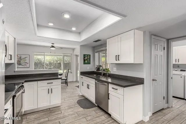 a kitchen with granite countertop a sink and cabinets