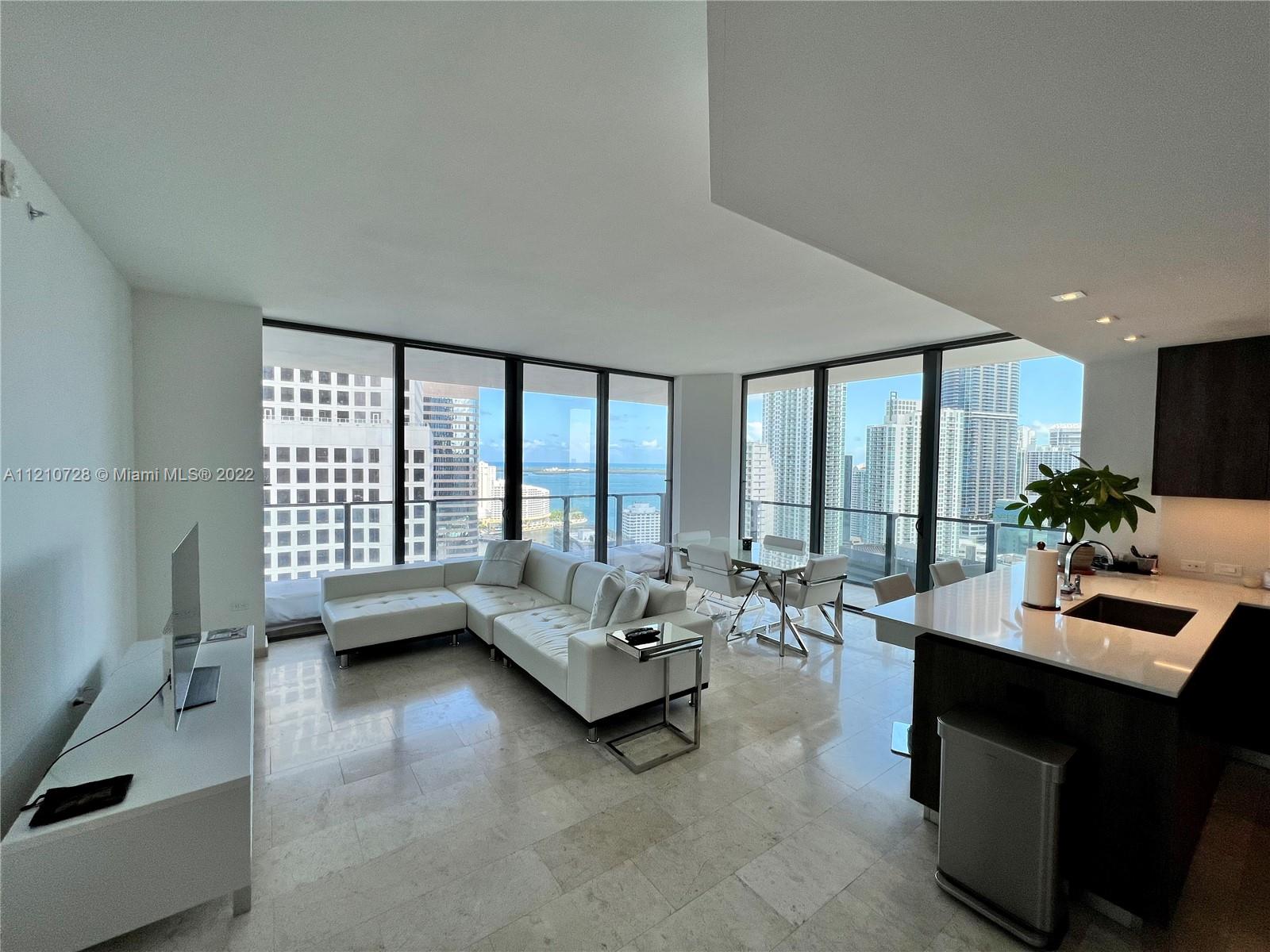 68 Southeast 6th Street, Unit 2801 Miami, FL 33131 - Photo 13 of 40 a living room with furniture and a large window