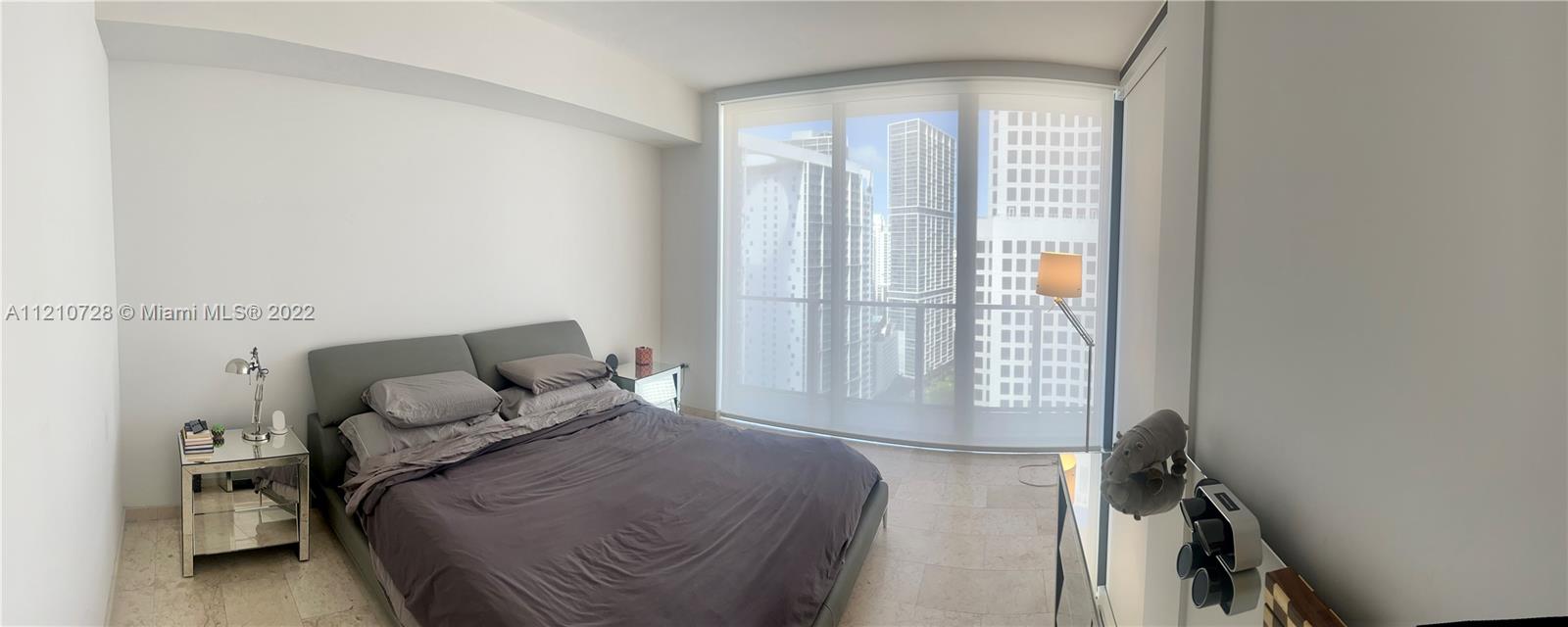 68 Southeast 6th Street, Unit 2801 Miami, FL 33131 - Photo 14 of 40 a bedroom with a bed and wooden floor