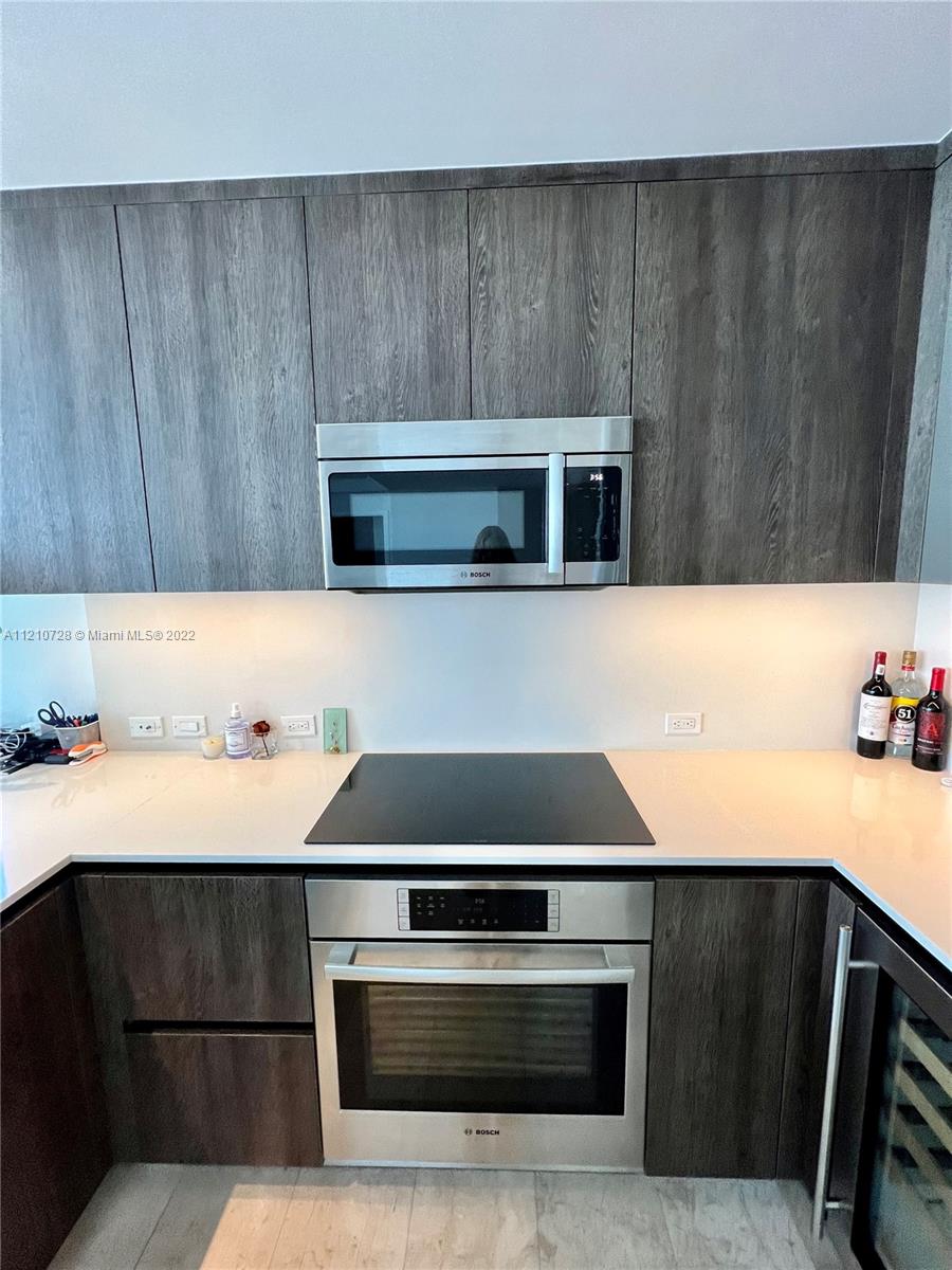 68 Southeast 6th Street, Unit 2801 Miami, FL 33131 - Photo 18 of 40 a kitchen with a stove and a microwave