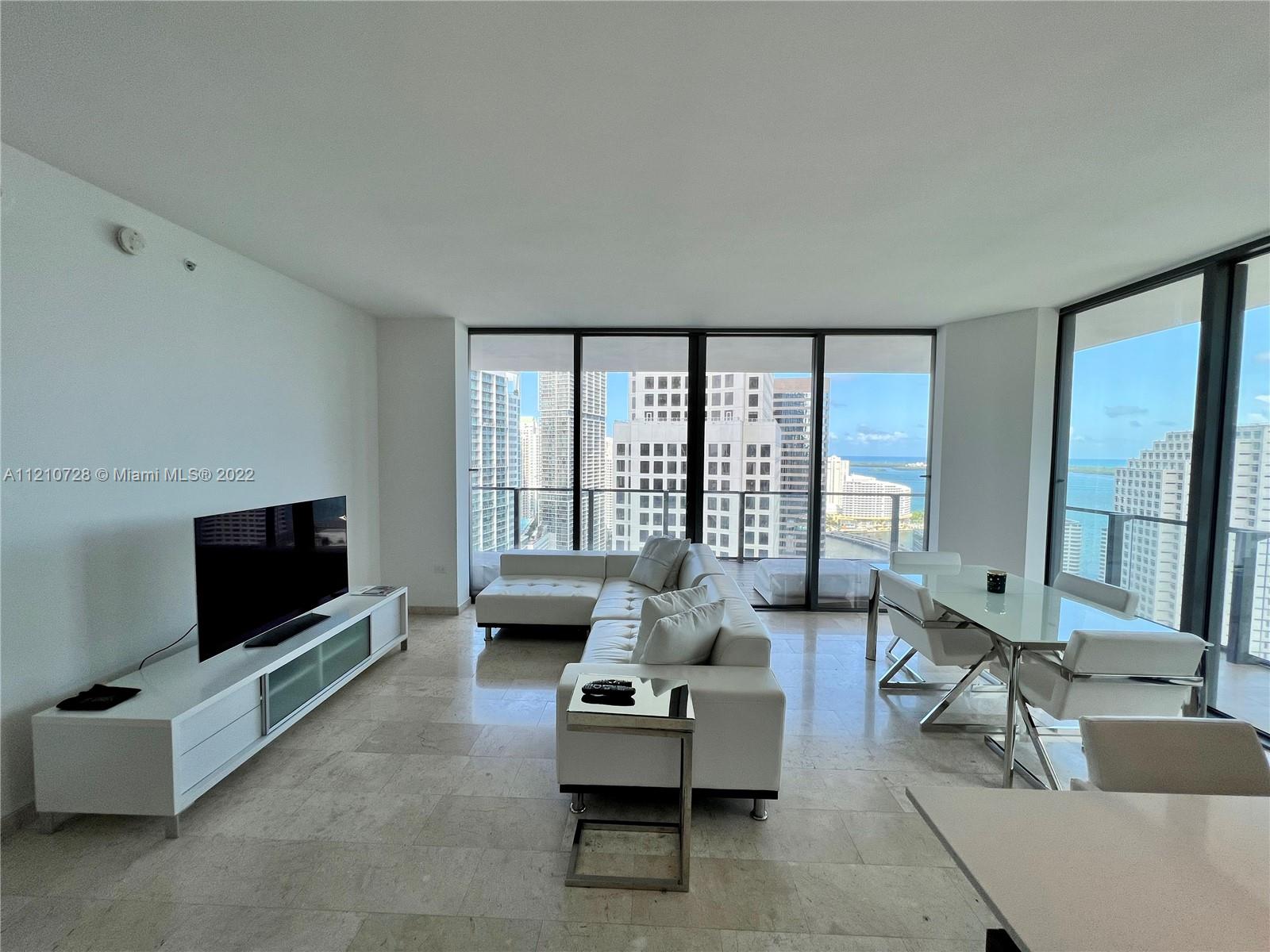 68 Southeast 6th Street, Unit 2801 Miami, FL 33131 - Photo 19 of 40 a living room with furniture and a flat screen tv