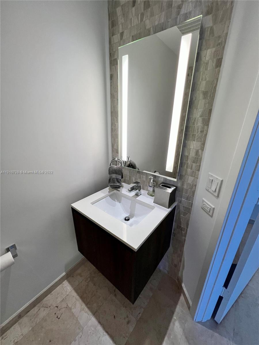 68 Southeast 6th Street, Unit 2801 Miami, FL 33131 - Photo 22 of 40 a bathroom with a sink and a mirror