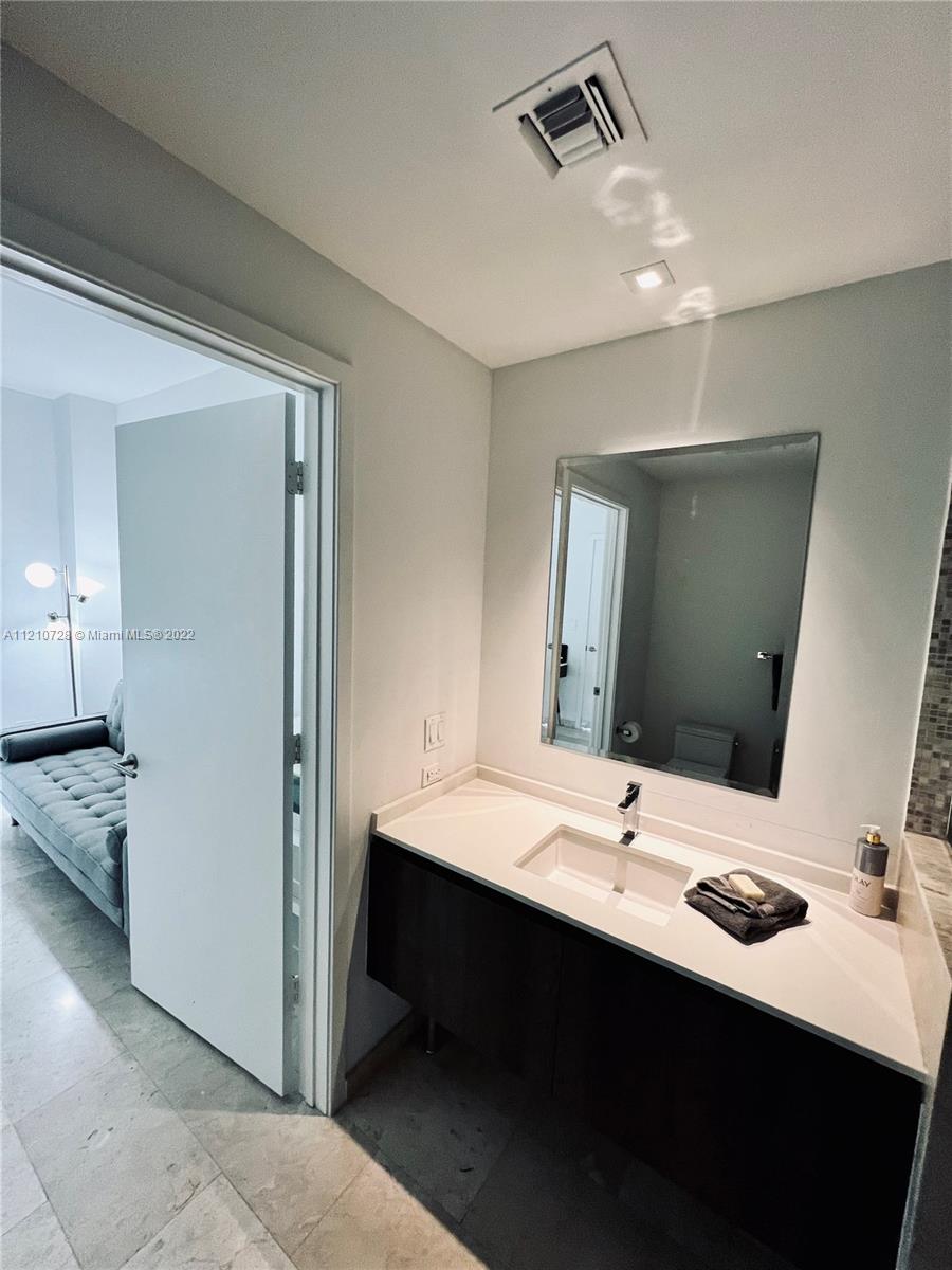 68 Southeast 6th Street, Unit 2801 Miami, FL 33131 - Photo 28 of 40 a bathroom with a sink and a mirror