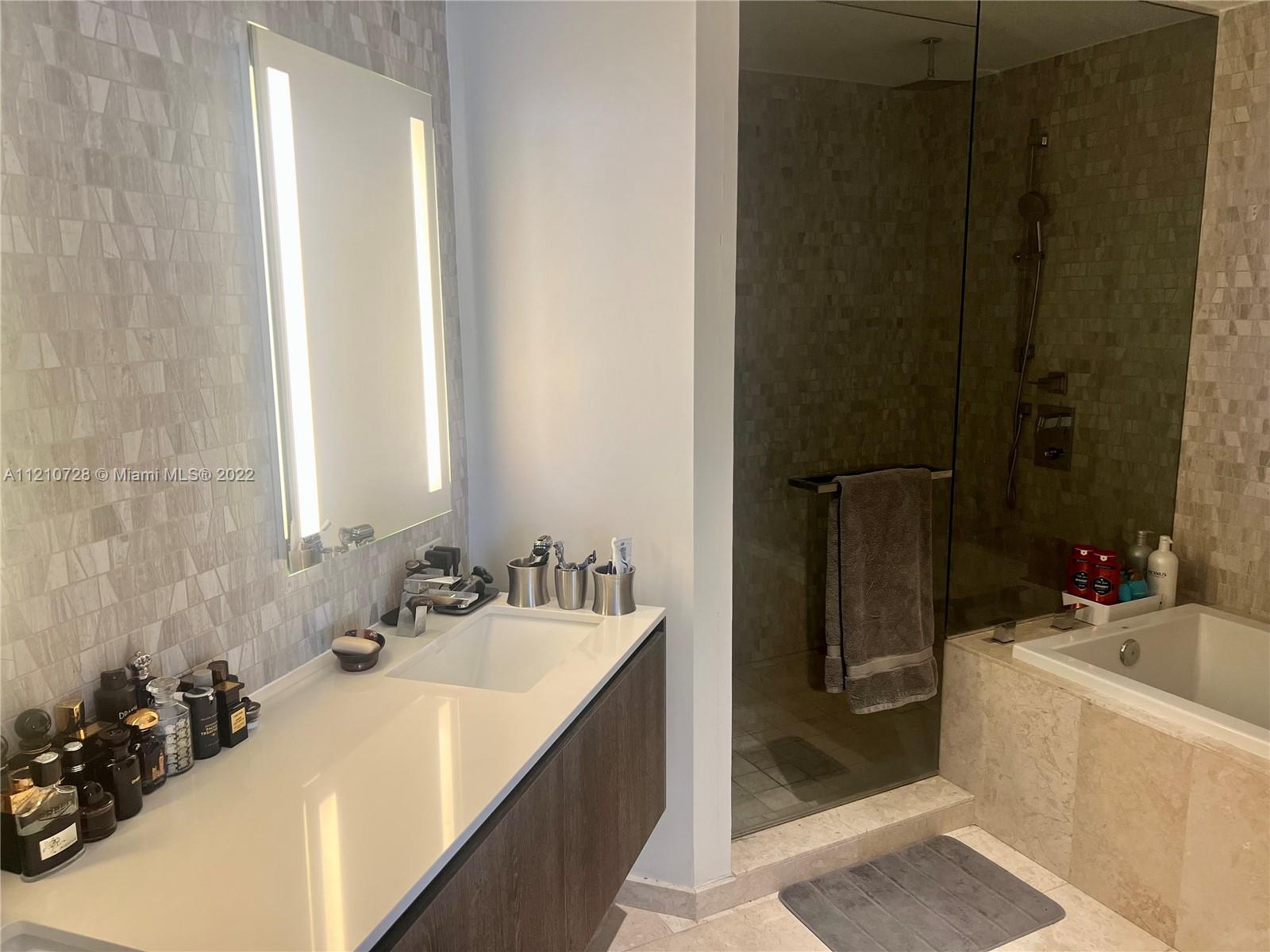 68 Southeast 6th Street, Unit 2801 Miami, FL 33131 - Photo 31 of 40 a bathroom with a sink and a mirror