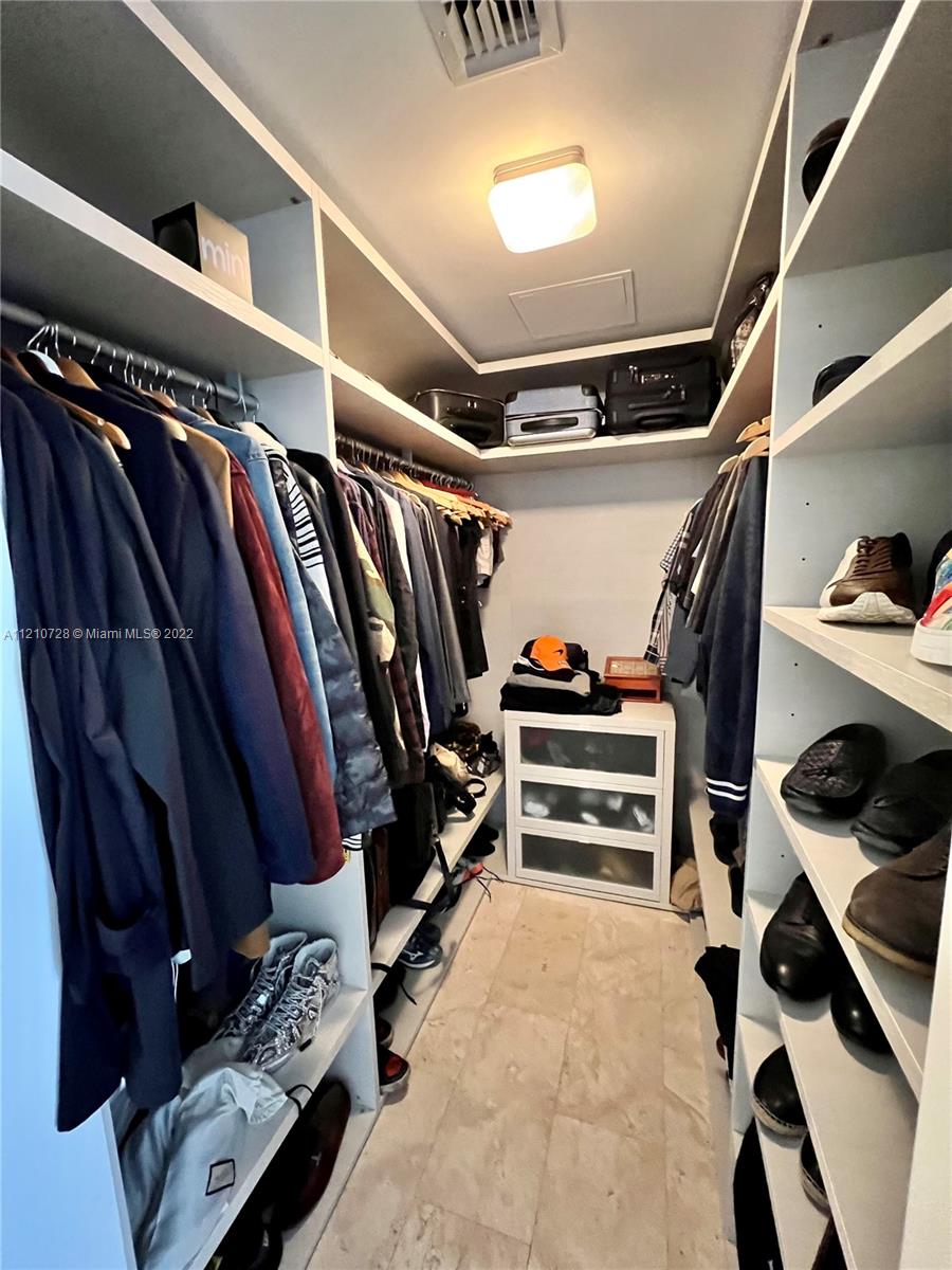 68 Southeast 6th Street, Unit 2801 Miami, FL 33131 - Photo 35 of 40 a view of walk in closet with clothes and shoes