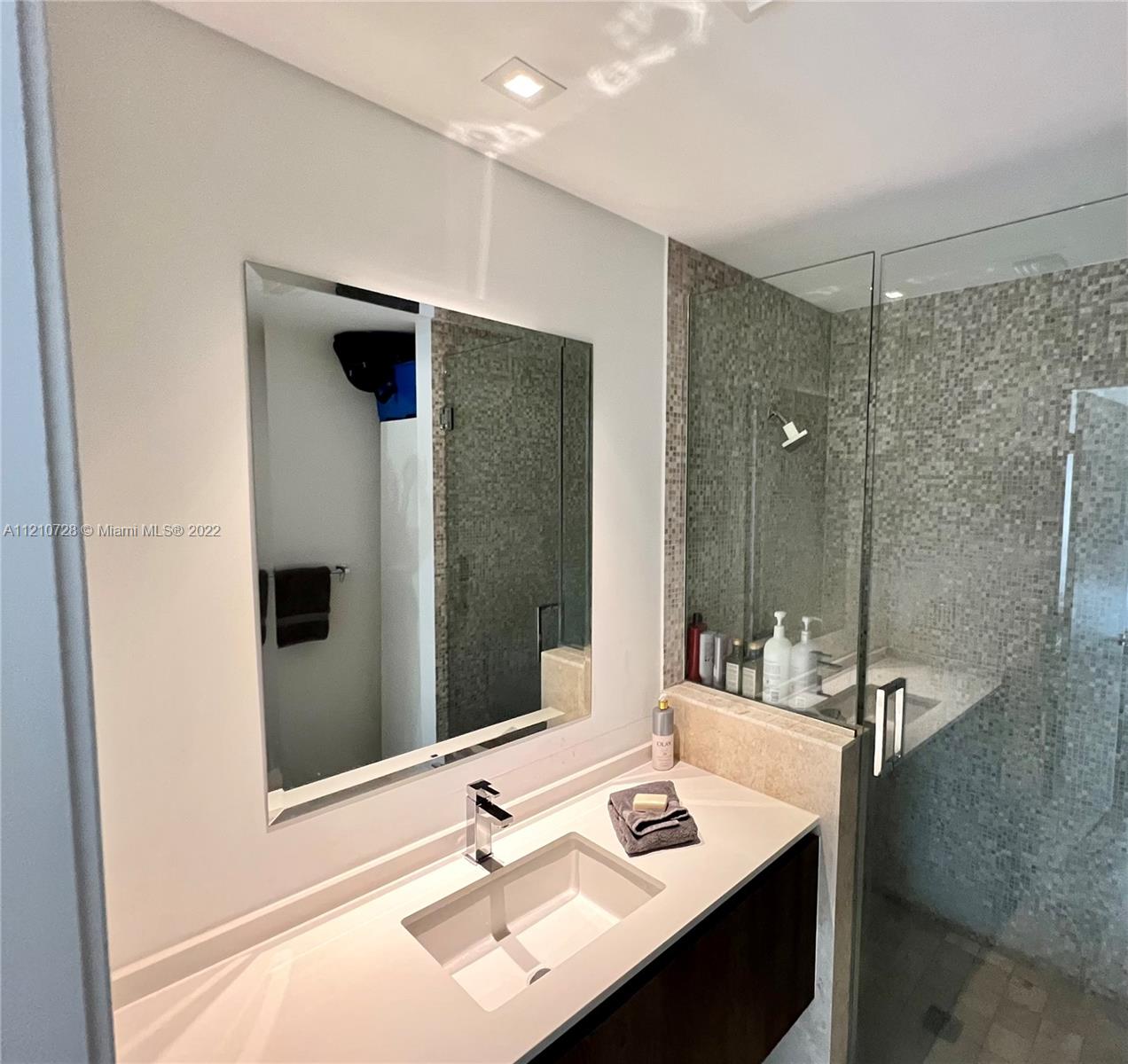 68 Southeast 6th Street, Unit 2801 Miami, FL 33131 - Photo 40 of 40 a bathroom with a sink and mirror