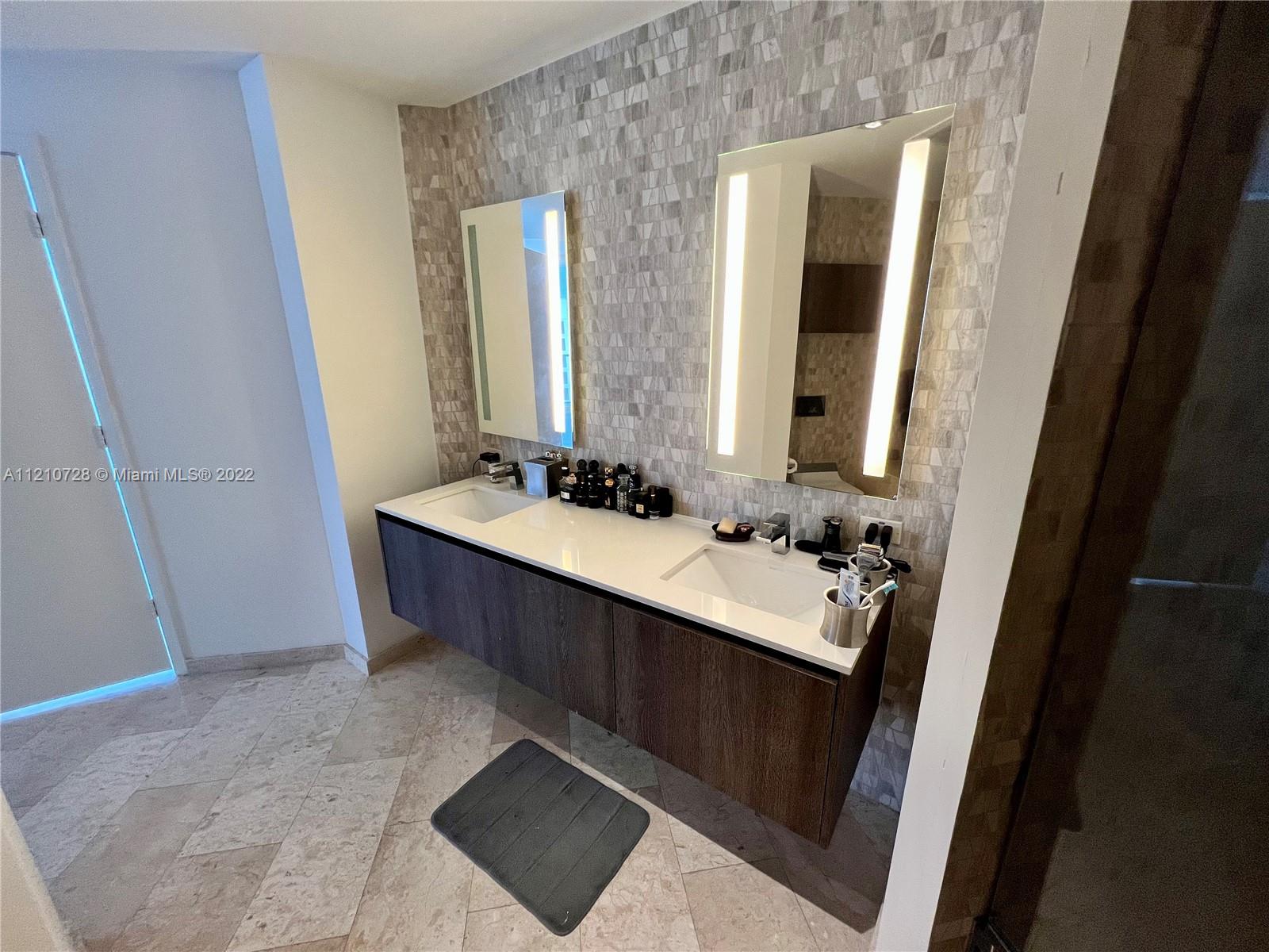 68 Southeast 6th Street, Unit 2801 Miami, FL 33131 - Photo 10 of 40 a bathroom with a double vanity sink and mirror