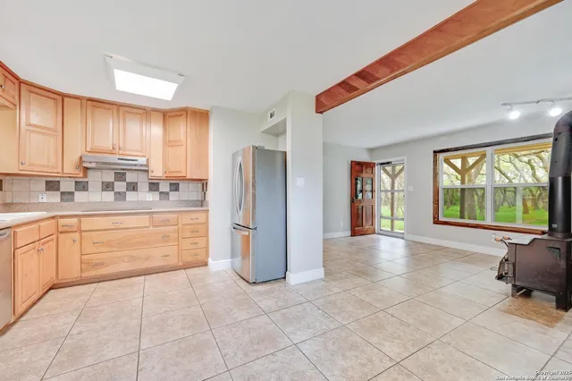 a kitchen with a refrigerator a stove top oven and a large window