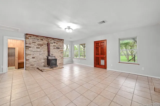 a view of an empty room with window and cabinet