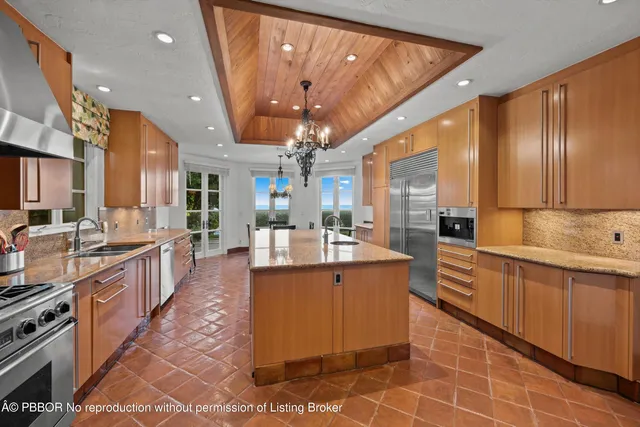 a large kitchen with kitchen island a sink stainless steel appliances and cabinets