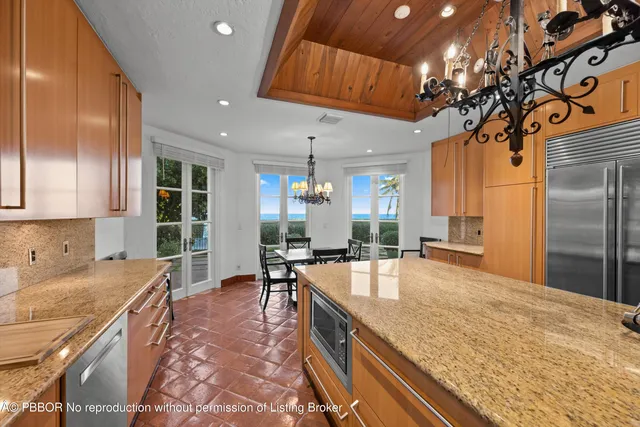 a large kitchen with kitchen island a large counter top stainless steel appliances and cabinets