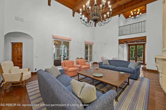 a living room with furniture a chandelier and a dining table