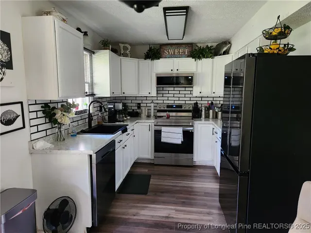 a kitchen with stainless steel appliances granite countertop a sink a stove and a refrigerator