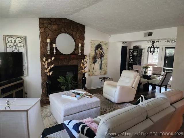 a living room with furniture a mirror and a fireplace